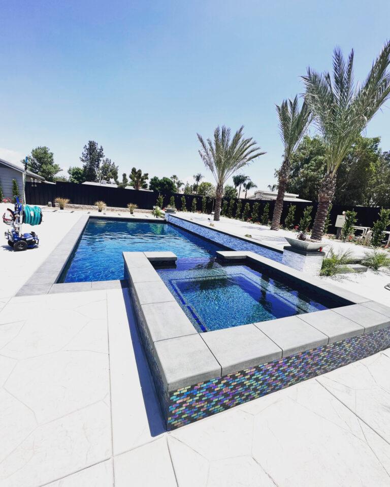 Modern backyard swimming pool with raised spa at residential home in Moreno Valley California