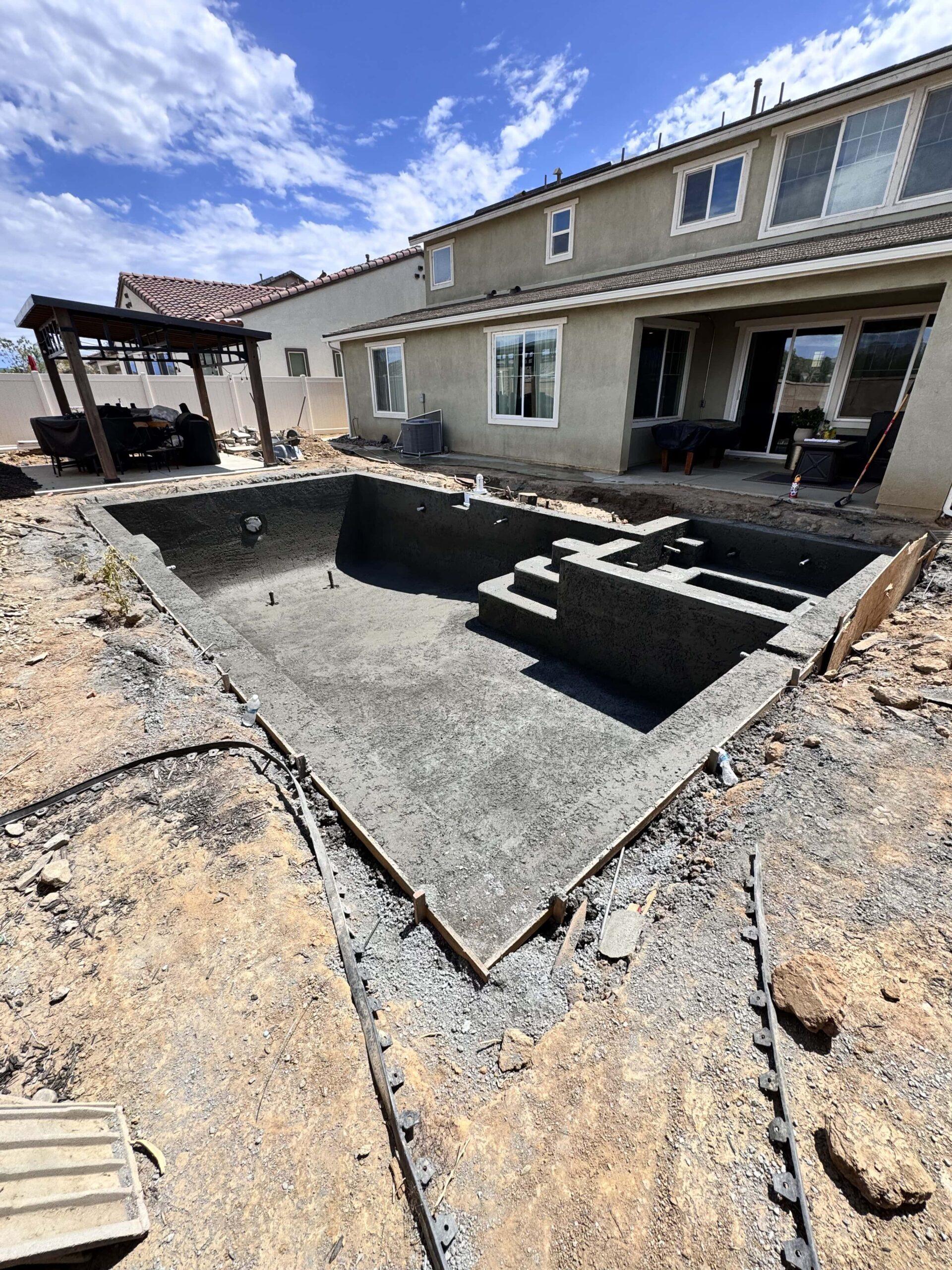 In-ground swimming pool under construction with fresh concrete shell