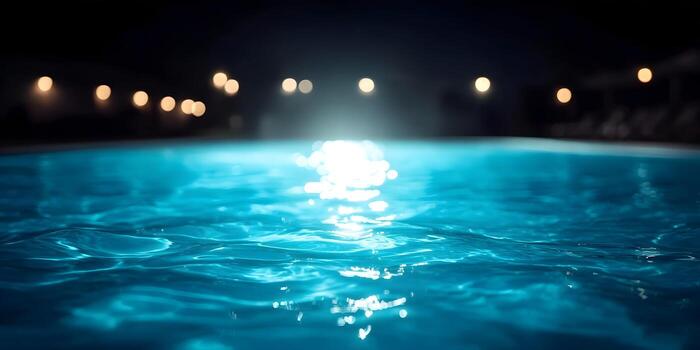 Illuminated swimming pool at night showing clear water and pool lighting